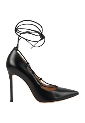 Chaussure à talon haut noire à bout pointu avec lacets enroulés autour de la cheville et talon aiguille fin, vue de profil sur fond blanc.