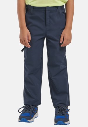 Kind draagt marineblauwe outdoorbroek en blauwe wandelschoenen, staat met ontspannen handen langs het lichaam.