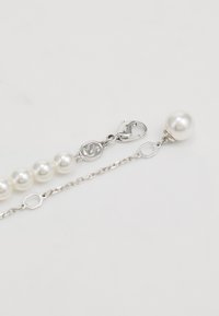 Pearl bracelet with silver chain, featuring multiple round pearls, a lobster clasp, and a hexagonal link detailing for adjustable length.