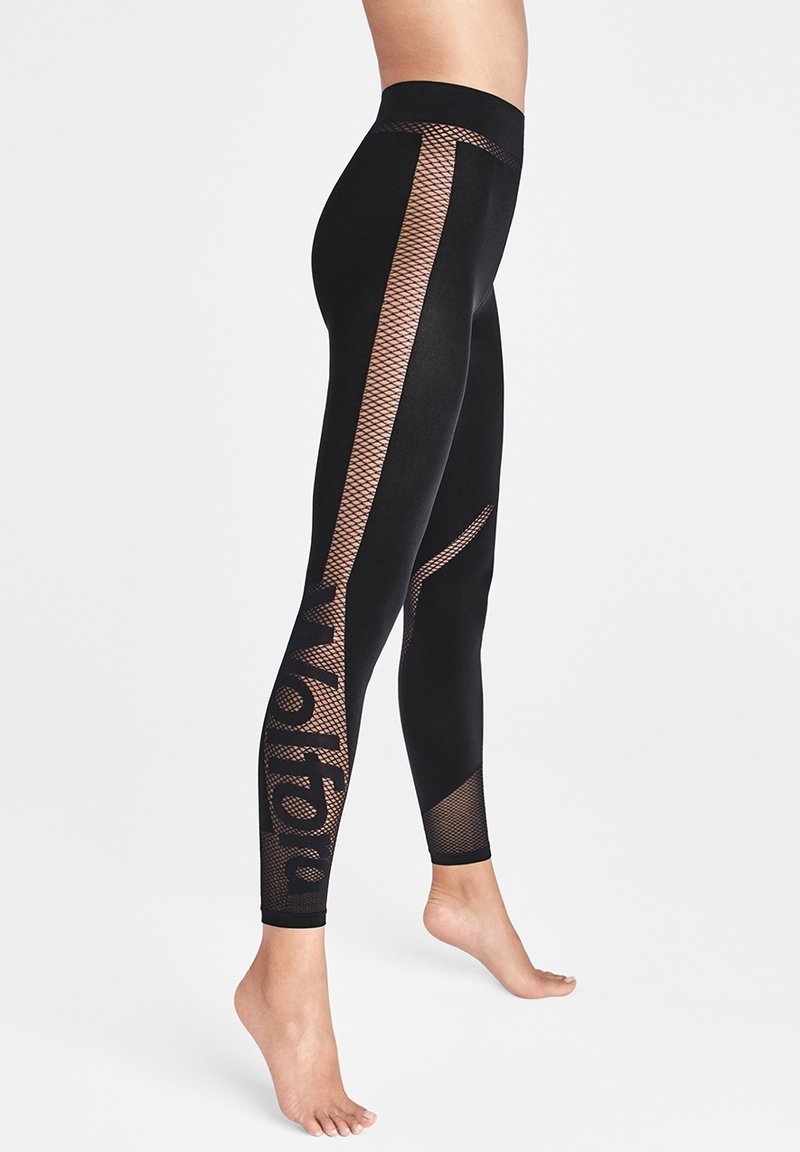 Svarta leggings med ett texturerat nätmönster längs sidorna, med en metallisk accent och logotyp på underbenet. Slät tyg och åtsittande passform.