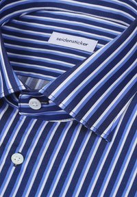 Chemise à rayures bleues et blanches avec des boutons blancs et une étiquette "seidensticker" à l'intérieur du col.