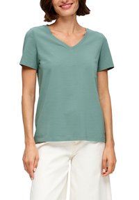 Miętowa koszulka z krótkim rękawem i dekoltem w kształcie litery V, wykonana z miękkiego, lekkiego materiału, z prostym dołem i luźnym krojem.