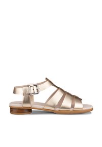 Arany metál bőrből készült lapos szandál, több pánttal, ezüst csatos bokapánttal és alacsony fa sarokkal.