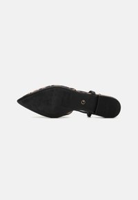 Zapato de tacón stiletto abierto con parte superior de estampado de leopardo, correa negra y punta afilada. Suela de goma texturizada con un revestimiento interior suave.
