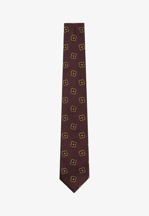 Brun slips med et gentaget mønster af små sorte og orange firbladede blomster, jævnt fordelt over stoffet.
