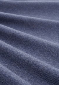 Tessuto blu scuro con una superficie morbida e texture, caratterizzato da una leggera elasticità e pieghe appena accennate, che indicano peso e caduta.