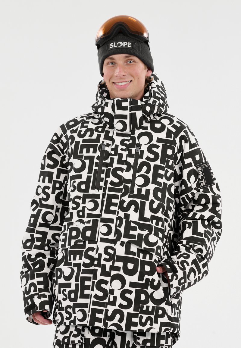 Mustavalkoinen kuviollinen lumiparka, jossa on korkea kaulus, vetoketjulliset taskut ja logo-patch hihassa. Siinä on rento istuvuus ja vedenpitävä materiaali.