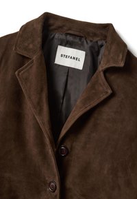 Braune Wildlederjacke mit einem Reverskragen, zwei dunklen Knöpfen und einem glatten Innenfutter mit der Aufschrift "STEFANEL".