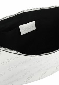 Pochette in pelle bianca con motivo testurizzato in rilievo. Presenta una fodera in tessuto nero e una cerniera argentata. L'interno è contrassegnato da un'etichetta con la scritta "KARL LAGERFELD."