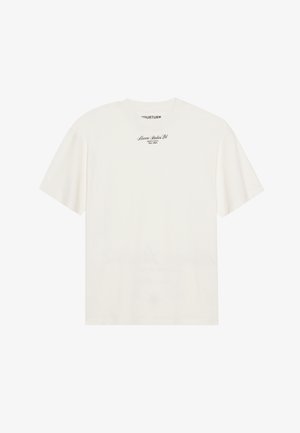 T-shirt de algodão off-white com mangas curtas e um corte relaxado. Apresenta um pequeno logotipo em texto preto no peito. Textura suave.