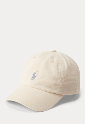 Beige baseballkasket med buet skygge og lille broderet polospillerlogo på forsiden, vist mod en ensfarvet hvid baggrund.