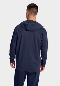 Navy blue hooded sweatshirt with long sleeves, made from smooth fabric. Features a relaxed fit and a kangaroo pocket at the front.