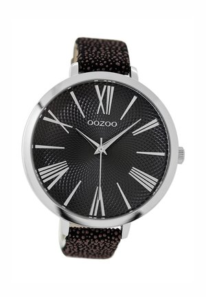 Montre noire avec un cadran texturé, des chiffres romains argentés et un boîtier en métal. Elle est équipée d'un bracelet en cuir brun foncé à motif.