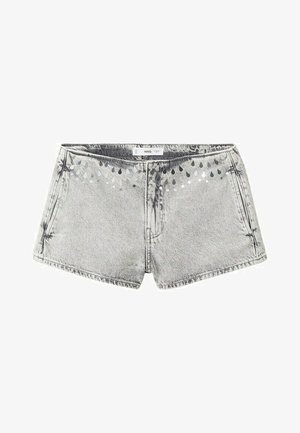 Lichtgrijze denim shorts met voorzakken en een patroon van kleine donkere en witte druppelvormige motieven langs de tailleband.