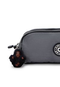 Trousse en nylon grise avec un porte-clés gorille en peluche noire attaché. Elle possède une fermeture éclair en haut et un écusson rond.