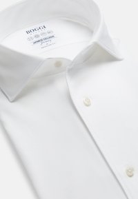 Witte button-up shirt met een spread collar, gemaakt van gladde stof. Bevat parelachtige knopen en een label dat aangeeft dat het een Japanse exclusieve ontwerp is.