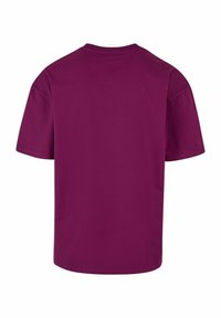 Tričko s krátkym rukávom v hlbokej fialovej farbe, bavlnená tkanina s okrúhlym výstrihom a rovnom spodným lemom. Minimalistický dizajn, žiadne viditeľné logo alebo vzory.