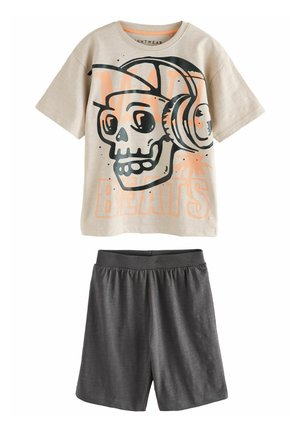 Light beige short-sleeve shirt with a black and orange skull graphic, paired with dark gray shorts featuring an elastic waistband.