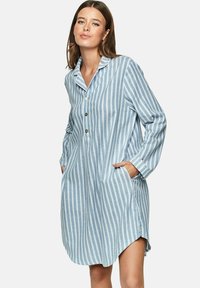 Chemise longue rayée bleu et blanc avec un bouton à l'avant, col, manches longues, poches latérales et un ourlet légèrement incurvé.