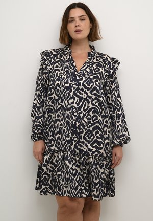 Ein langärmliges Kleid mit Tiermuster in Marineblau und Creme, mit Rüschen an den Schultern, einem V-Ausschnitt und einem ausgestellten, gestuften Saum. Texturiertes Material.
