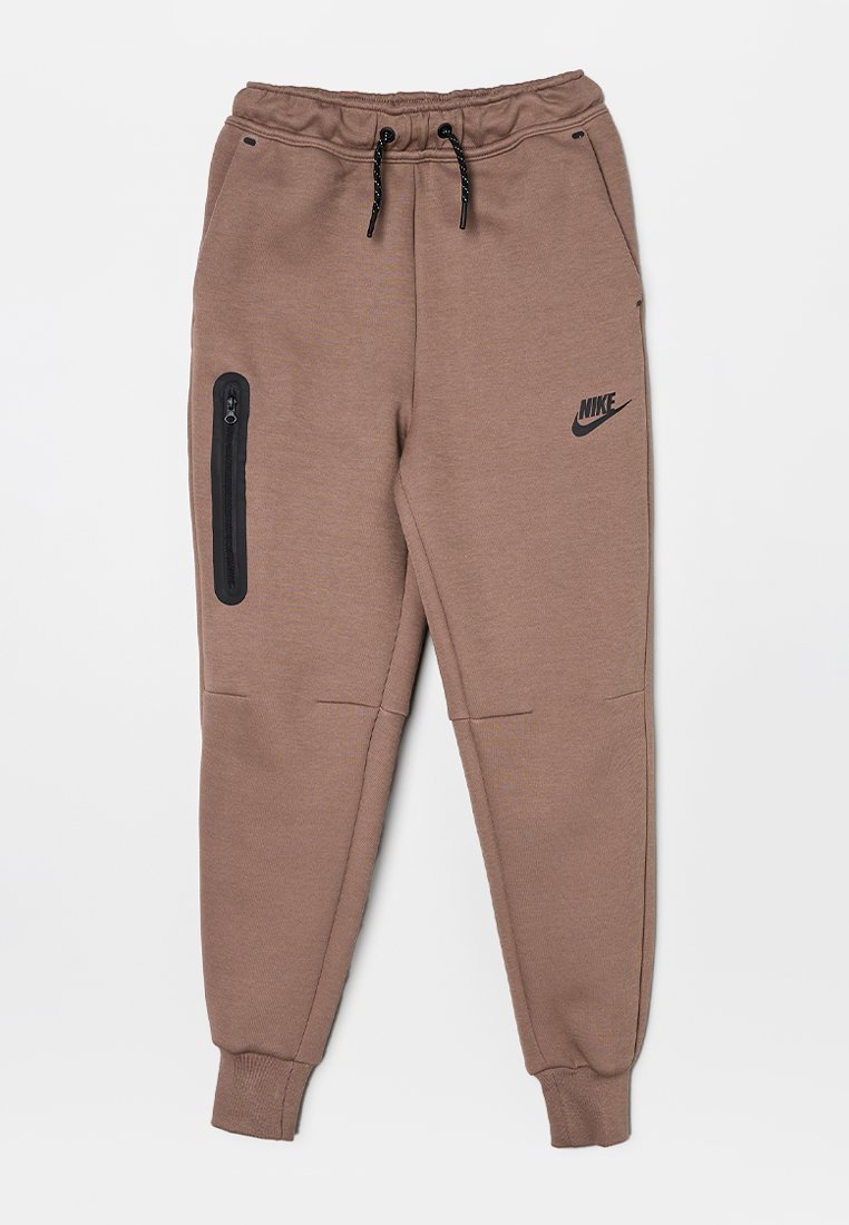 Pantalones de chándal Nike marrones con una cintura elástica, detalle de cordón ajustable, bolsillo lateral con cremallera y piernas ajustadas. Fabricados en un suave tejido texturizado.