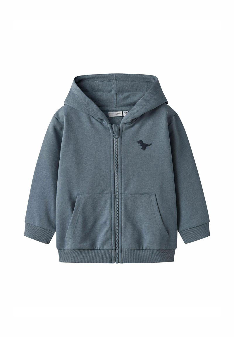 Sivi zip-up dukserica od mekog materijala, s prednjim kengur džepom i logotipom crtanog dinosaura na lijevoj strani grudnog koša.