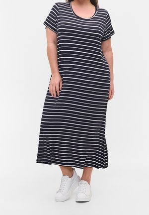 Robe maxi rayée bleu marine et blanche avec des manches courtes, un col rond et des fentes sur les côtés, associée à des baskets blanches. Fabriquée en tissu doux.