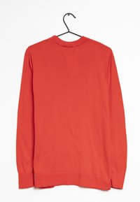 Maglione rosso a maniche lunghe esposto su un appendiabiti, con collo tondo, polsini a coste e un tessuto liscio e leggero.
