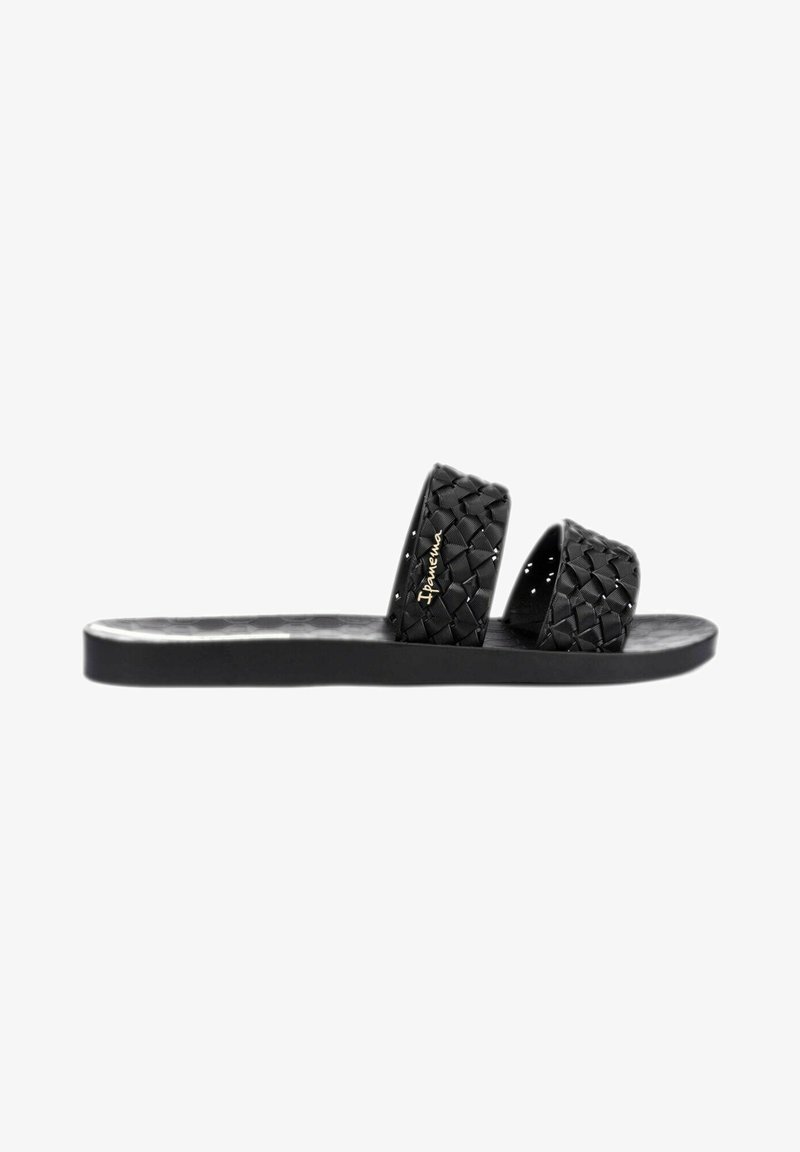 Sandales noires plates avec deux sangles tressées, une semelle lisse et un motif hexagonal sur le pied. Détails de la marque inclus.