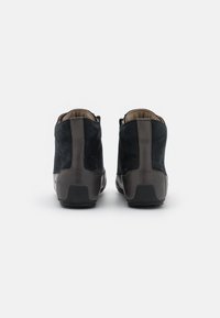 Stivaletti in suede neri con un elegante accento in pelle grigia liscia, caratterizzati da una punta arrotondata e una suola in gomma testurizzata.