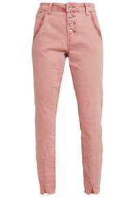 Ljust rosa bomullbyxor med slim fit, femknapplås och sidofickor. Strukturerad tyg med synlig sömnad och glipor vid anklarna.