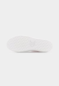 Semelle de chaussure en caoutchouc blanc avec un motif quadrillé texturé et un logo "CK" embossé au centre.