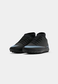 Scarpe da ginnastica nere con design a mezza altezza, tomaia sintetica testurizzata e swoosh azzurro a contrasto. Presentano una suola in gomma con tacchetti.