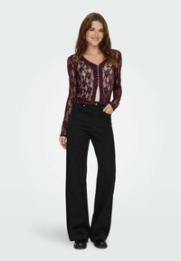 Burgundy blondevlækket cardigan med lange ærmer og knaplukning foran, parret med højtaljede sorte brede bukser. Glat tekstur, afslappet design.