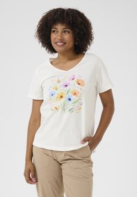 Short-sleeved, V-neck t-shirt in cream cotton, featuring a floral print in pastel colors. Designed with a relaxed fit and gentle texture.