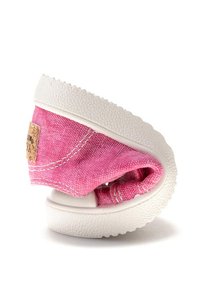 Zapatilla de lona rosa con suela de goma blanca, forma redondeada, detalles de costura y un pequeño parche de marca en el costado.