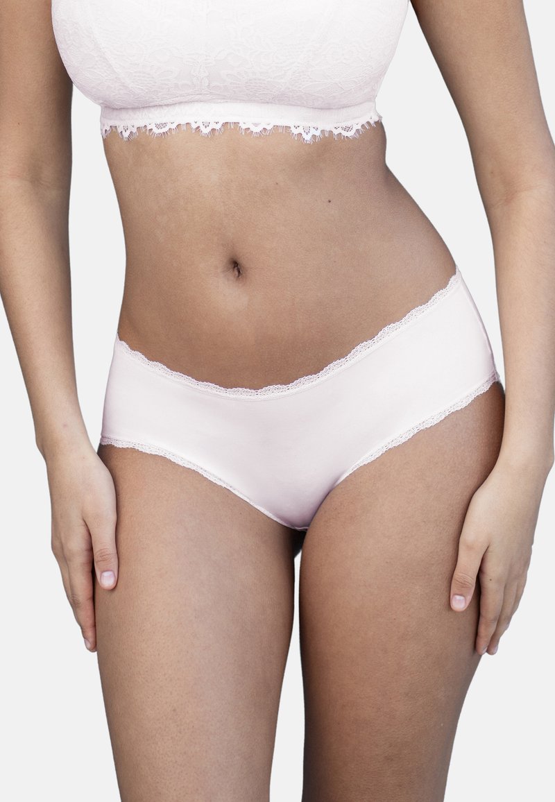 Helle rosa Baumwollunterwäsche für Damen mit einem gewellten Spitzenbund und ohne sichtbare Muster oder Verzierungen. Glatte Textur.