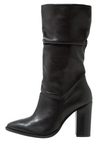 Bota de cuero negro hasta la rodilla con parte superior arrugada, punta afilada y tacón alto y grueso. Textura suave y detalles de costura limpios.