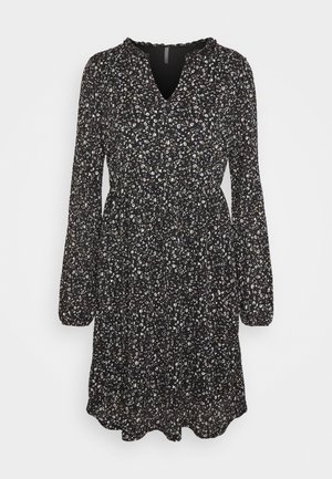 Robe noire à motifs floraux avec des manches longues, un décolleté en V et une taille froncée ; le motif comporte de petites fleurs blanches et pastel sur un fond sombre.