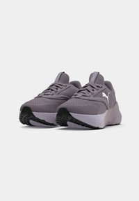 Pantofi sport violeți cu un superior din plasă texturată, talpă exterioară din cauciuc negru în contrast și detalii proeminente ale logo-ului pe lateral.