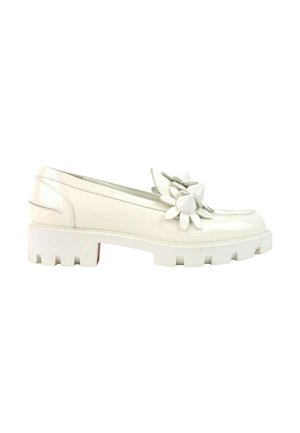 Mocassin en cuir verni blanc avec semelle épaisse et grande fleur décorative sur le dessus, vue de côté sur fond blanc.