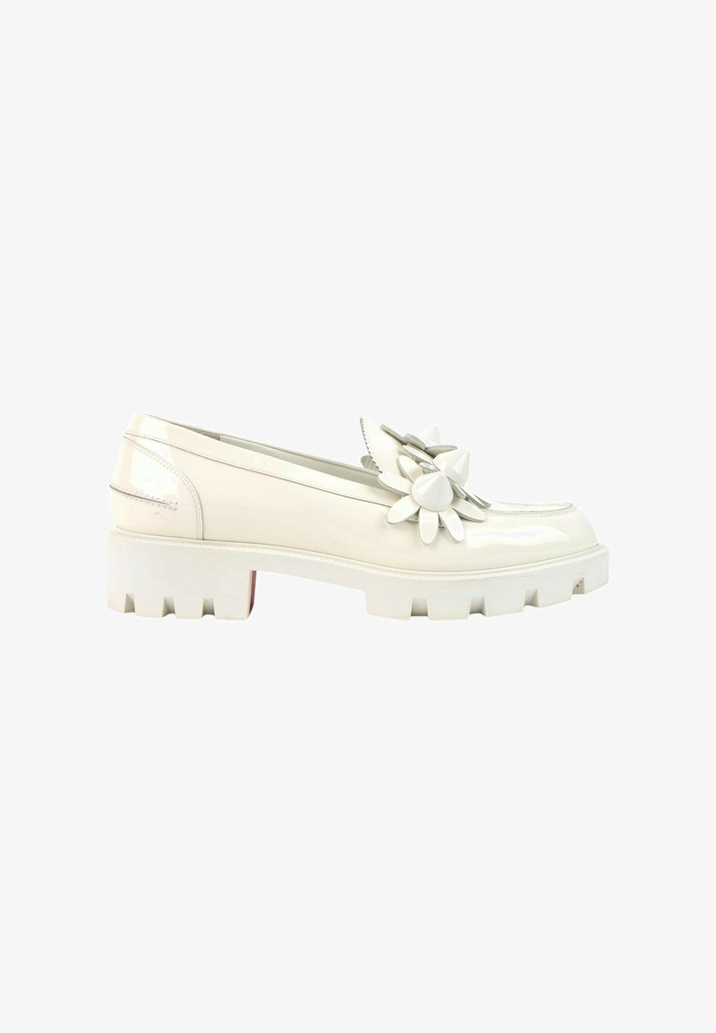 Mocassin en cuir verni blanc avec semelle épaisse et grande fleur décorative sur le dessus, vue de côté sur fond blanc.