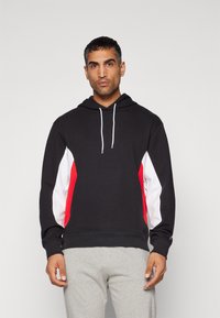 Hanorac negru cu glugă, având panouri laterale roșii și albe, dotat cu un capuz cu șnur și manșete ribbate pentru un fit casual.