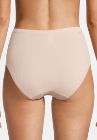 Beige högmidjade underkläder med en slät textur och sömlösa kanter, som har en matt yta för minimala synliga linjer.