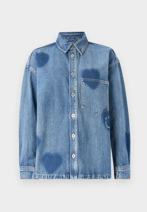 Denim shirt in light blue featuring heart-shaped accents, a pointed collar, front pocket, and button placket. Soft, textured fabric.