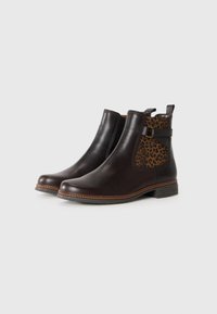 Bottines en cuir marron avec un panneau à imprimé léopard, des côtés élastiques et une semelle plate en caoutchouc. Coutures détaillées autour de la semelle.