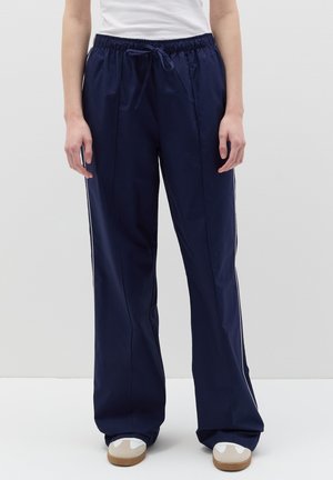 Pantalones de color azul marino, ligeros, con cintura elástica y cordón. Presentan franjas laterales y un ajuste suelto y fluido.