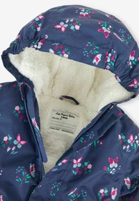 Jachetă pentru copii de culoare bleu marin cu glugă, imprimeu floral și cu fluturi, căptușeală moale din blană sintetică, fermoar frontal și etichetă pentru identificare personală.