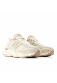 Sneakers beige con una parte superiore testurizzata, realizzata in morbido camoscio e materiali in rete. Accenti in crema a contrasto e logo "N" sul lato.
