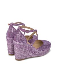 Sandales compensées violettes avec une semelle en corde tissée, ornées de strass transparents sur la tige en daim. Sangle de cheville réglable incluse.